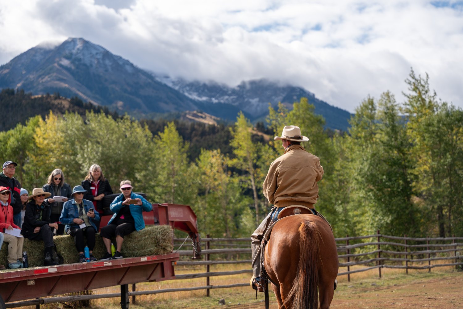 A man on a horse with a group of people watching him