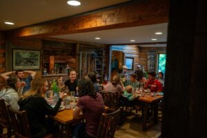 A group of people eating together at a large wooden table