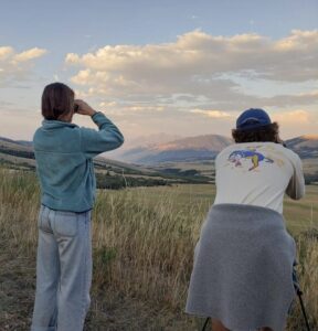 Two people on a hill with binoculars