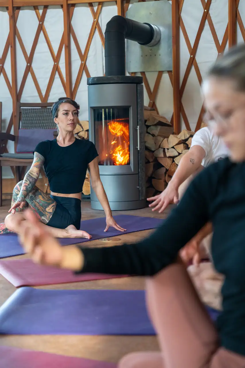 A woman is practicing yoga in front of a fireplace