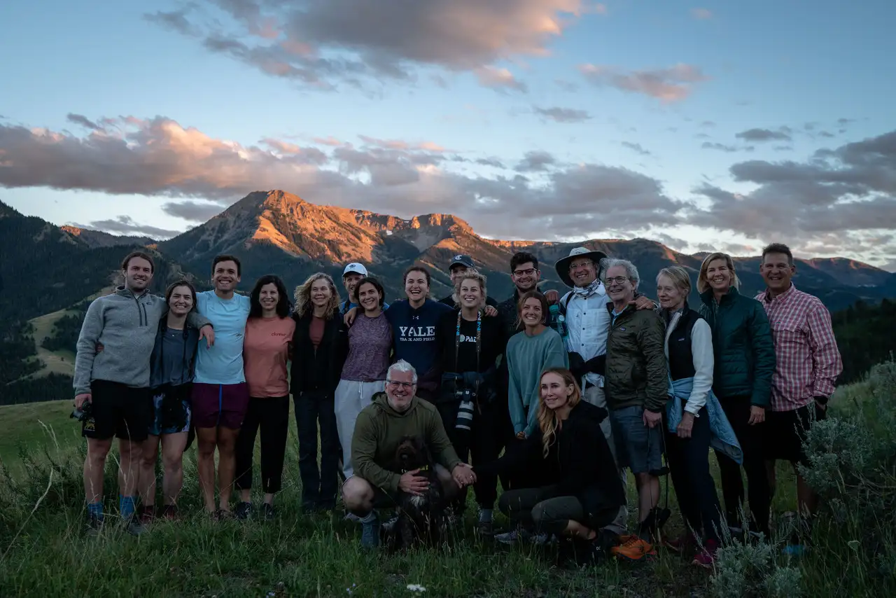 A group of people posing for a photo in front of a mountain range