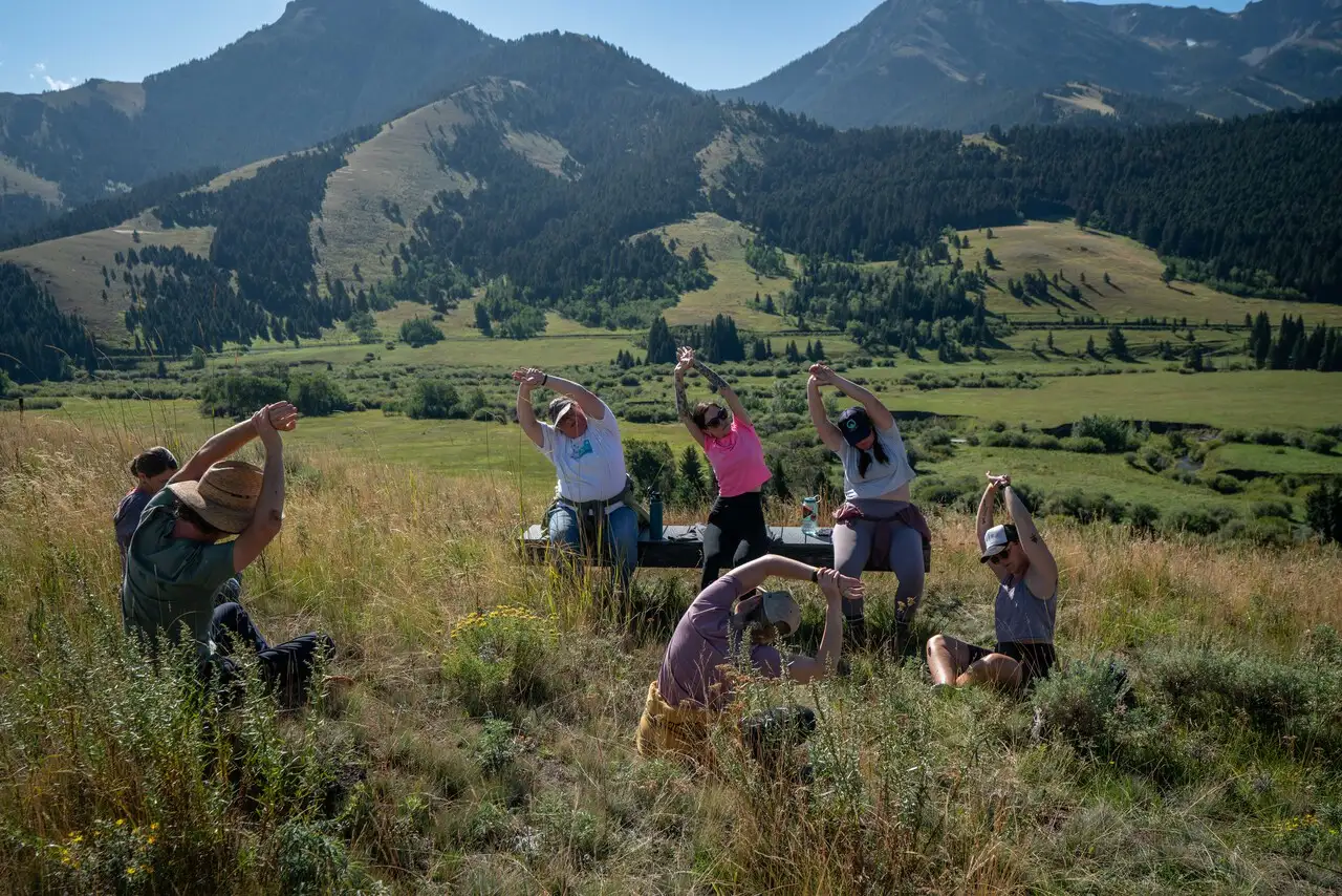 A group of people doing yoga on a hillside