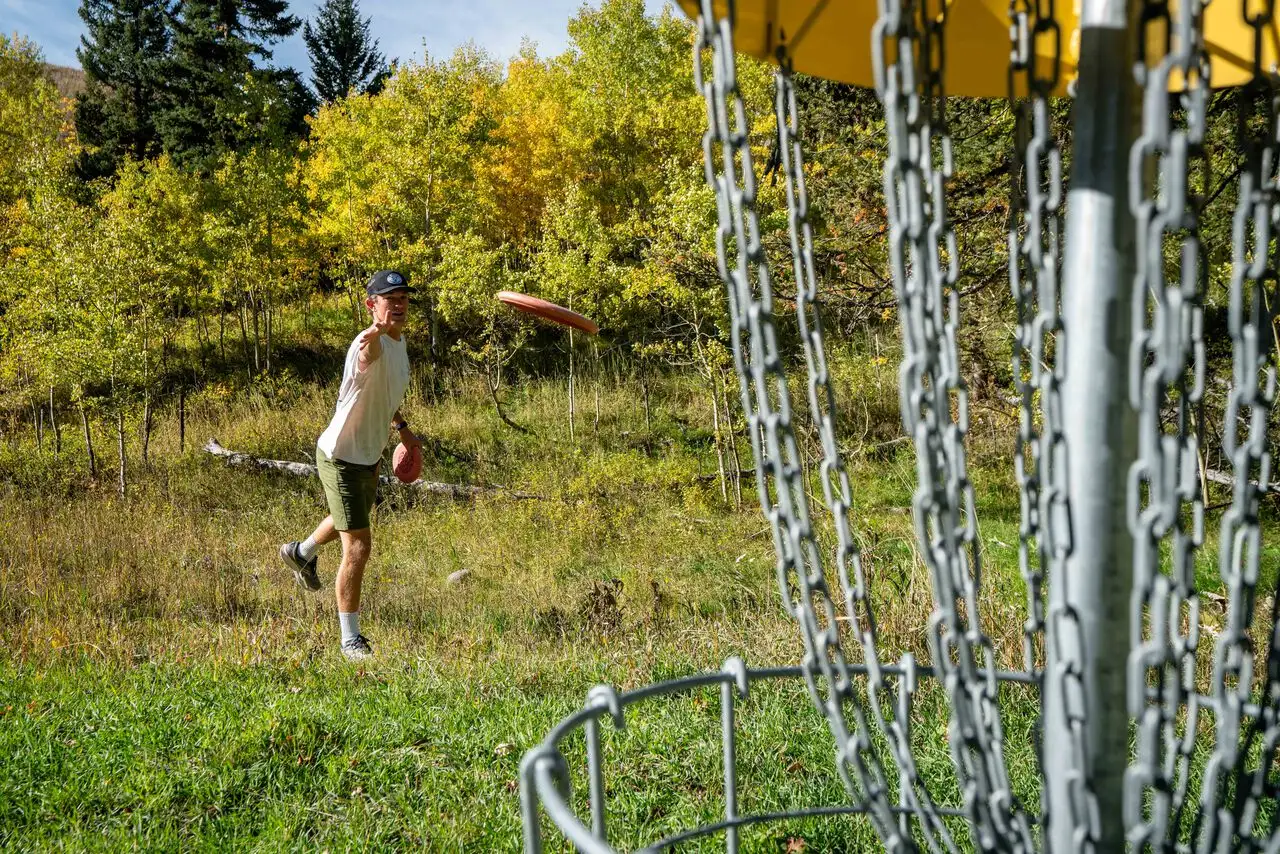 A man playing frisbee in a park