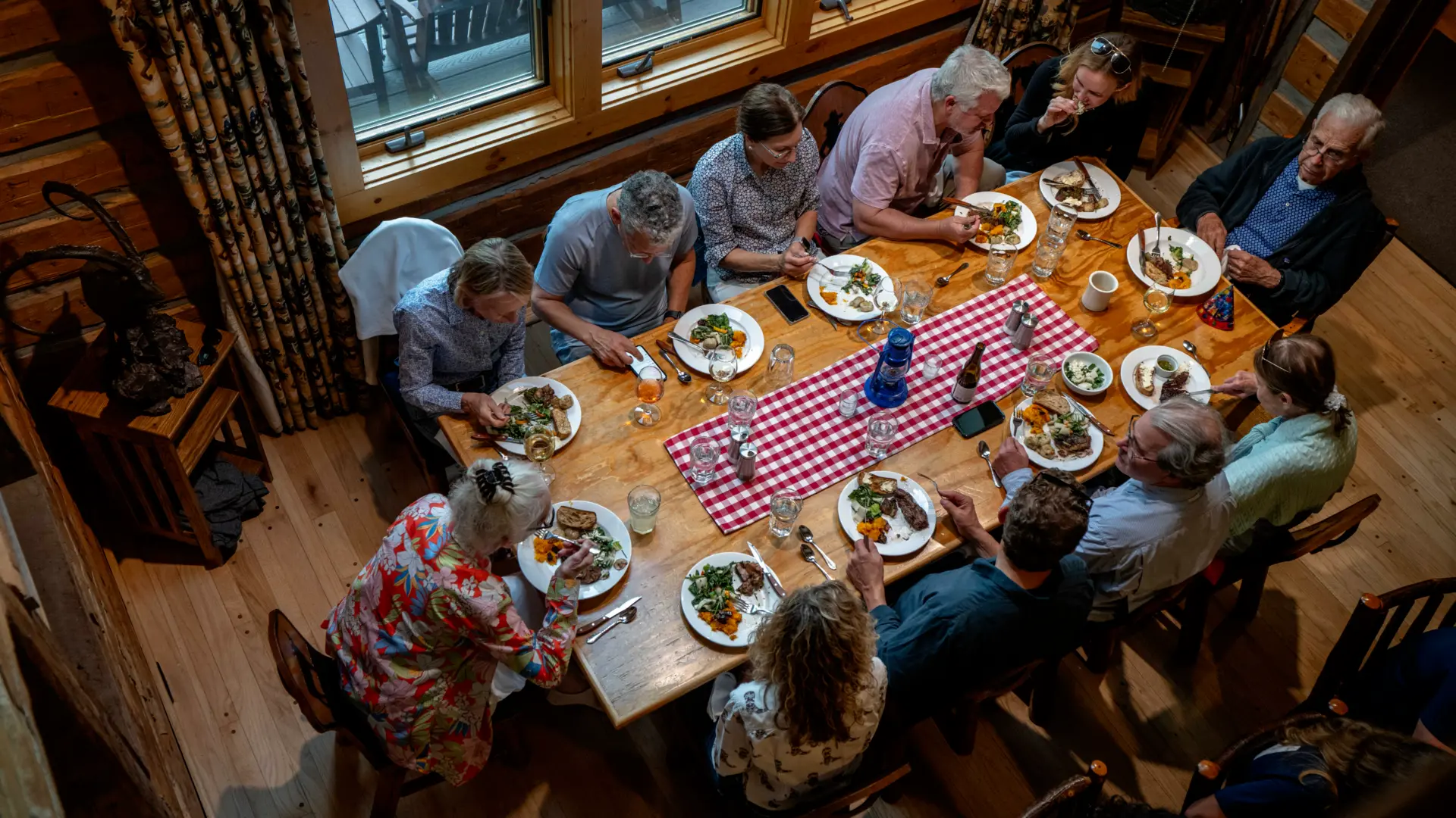 A group of people sitting around a table, enjoying a meal together