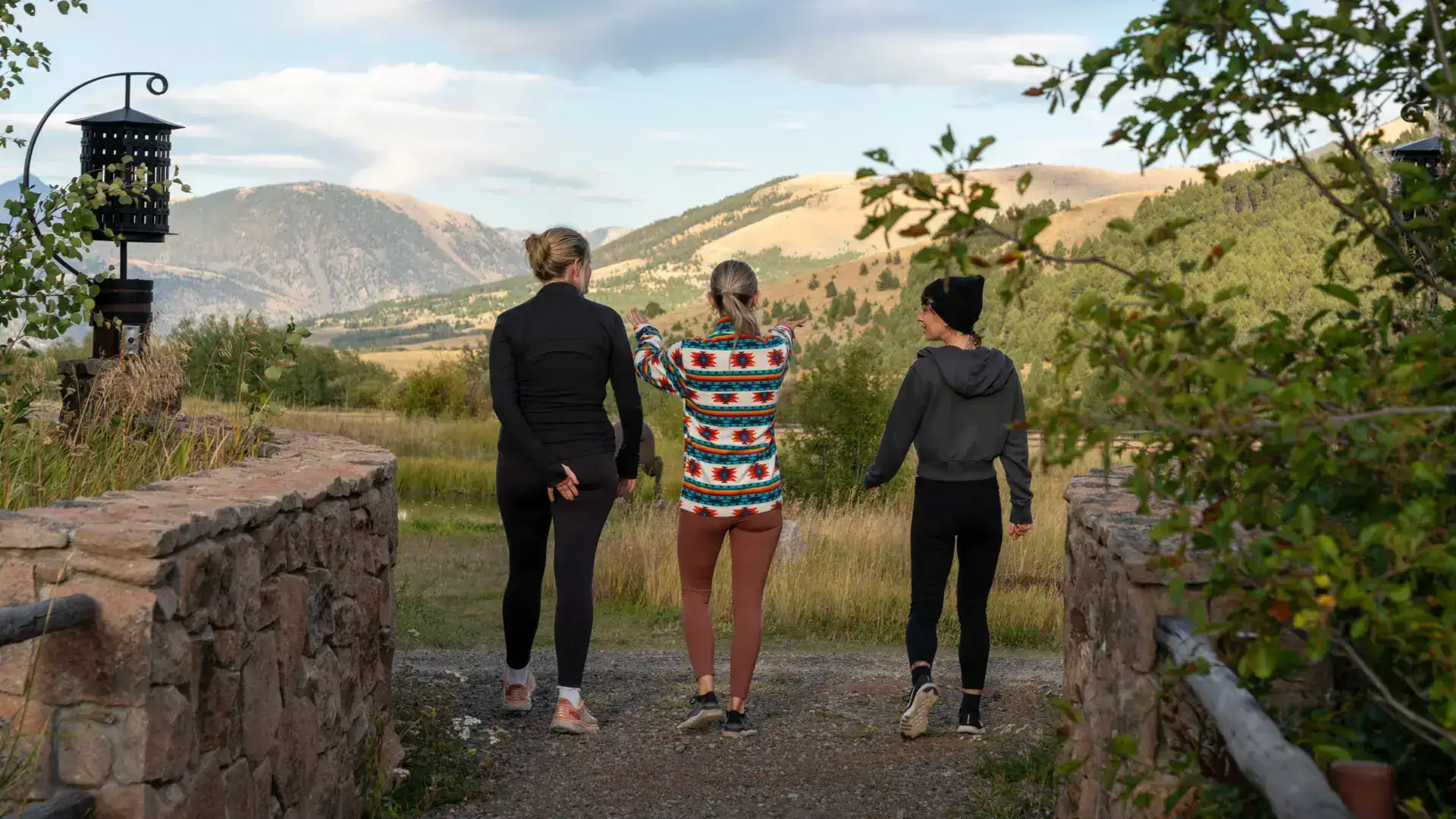 Three women walking together on a dirt road