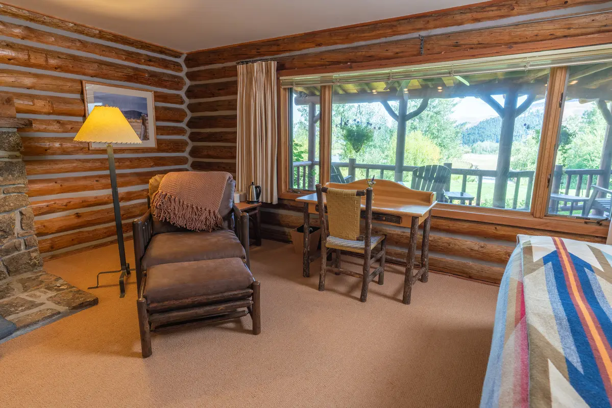 A living room with a large window and deck outside