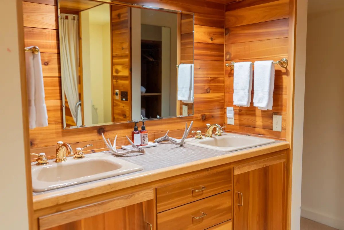 A bathroom with a wooden vanity and a large mirror above it