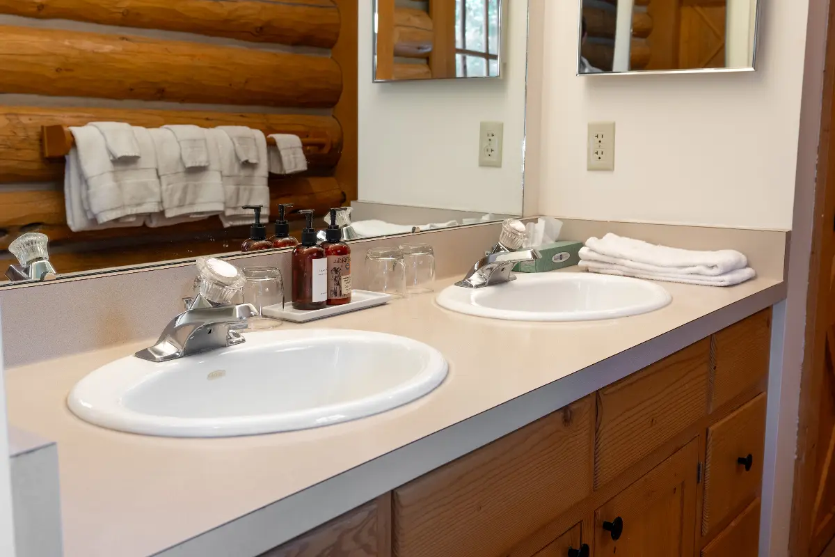 A bathroom with a double sink vanity and a mirror above it