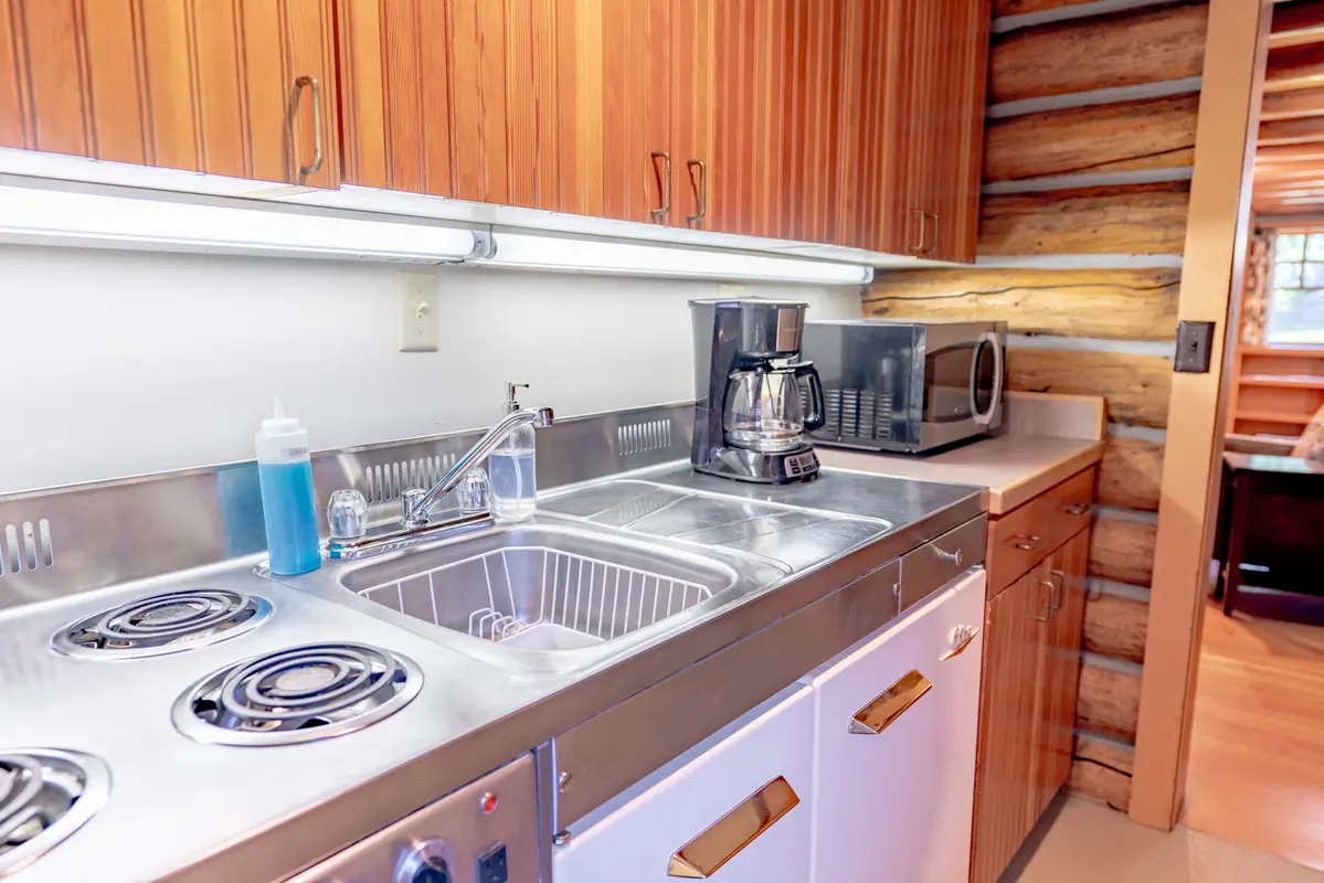 Kitchen with a sink, coffee maker, microwave, and stove top oven