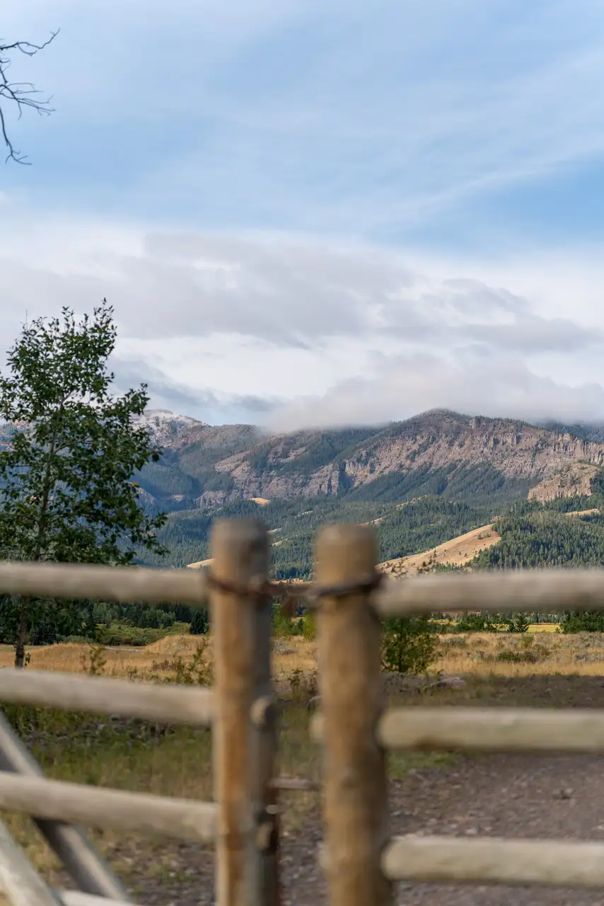 A wooden fence in front of a mountain range