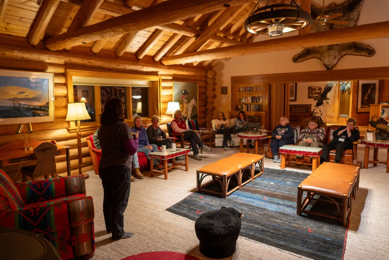 A group of people gathered in a living room, having a conversation