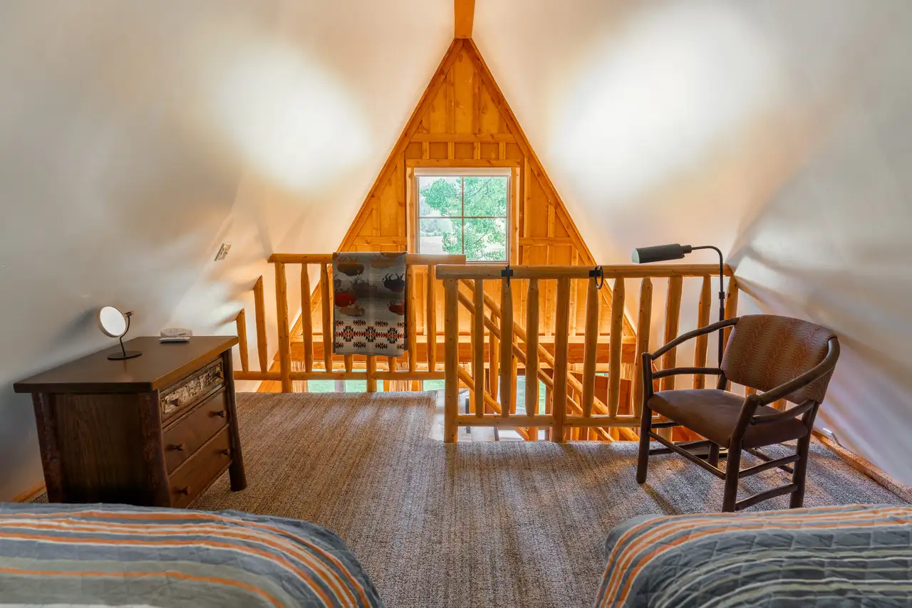 A cozy room with a loft bedroom and a staircase