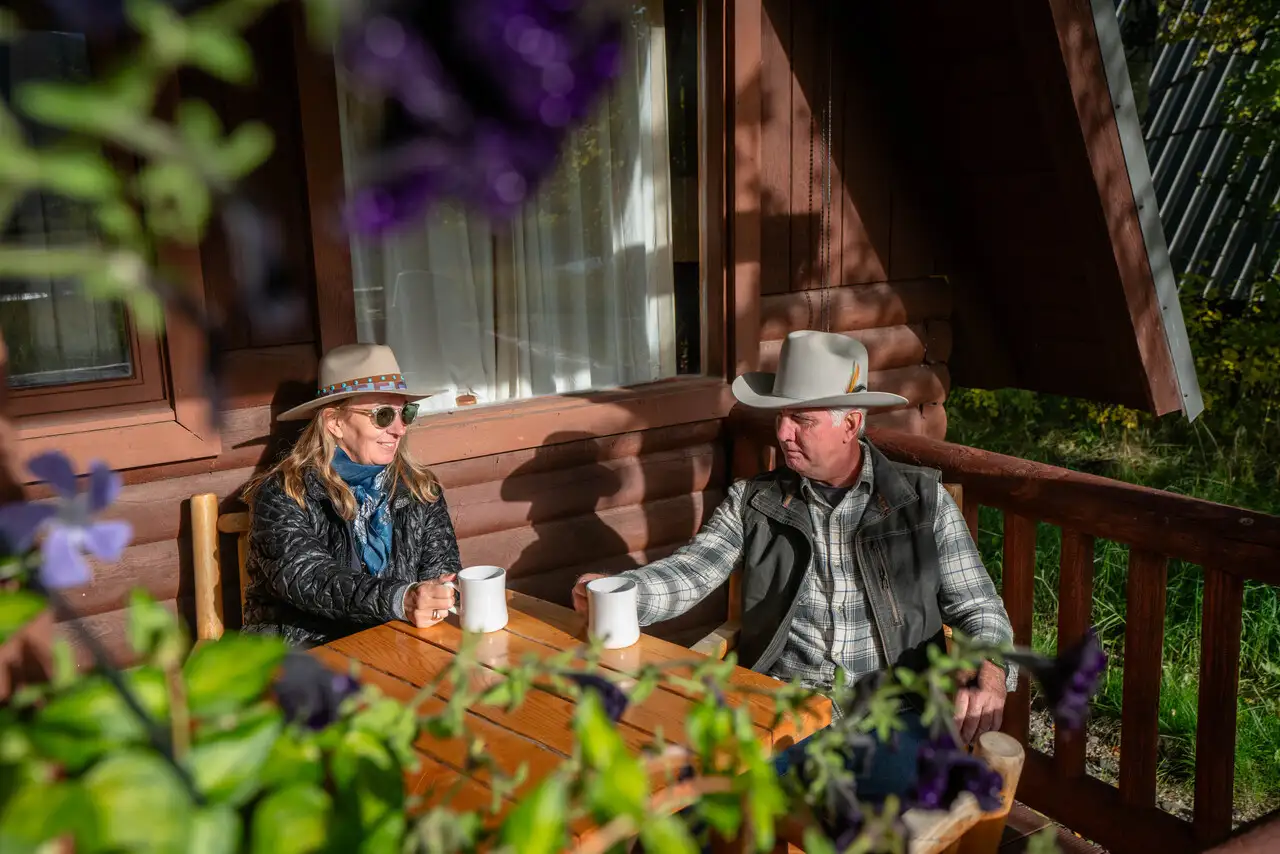 A man and a woman sitting at a table outside, enjoying their coffee and each other's company