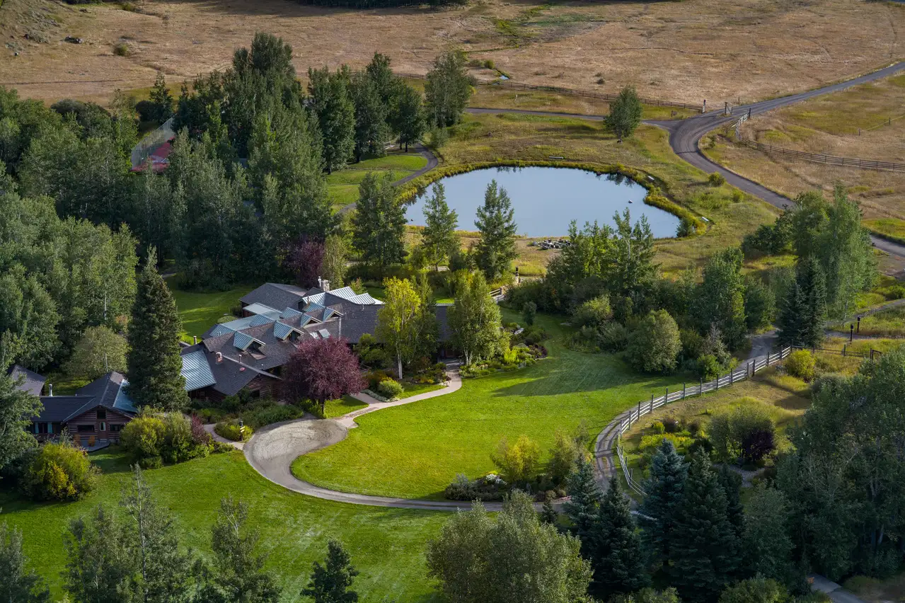 A house with a circular driveway and a lake in the backyard