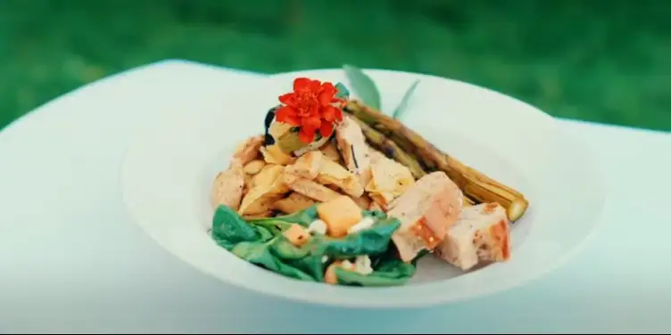 A white bowl with chicken, broccoli, and cheese