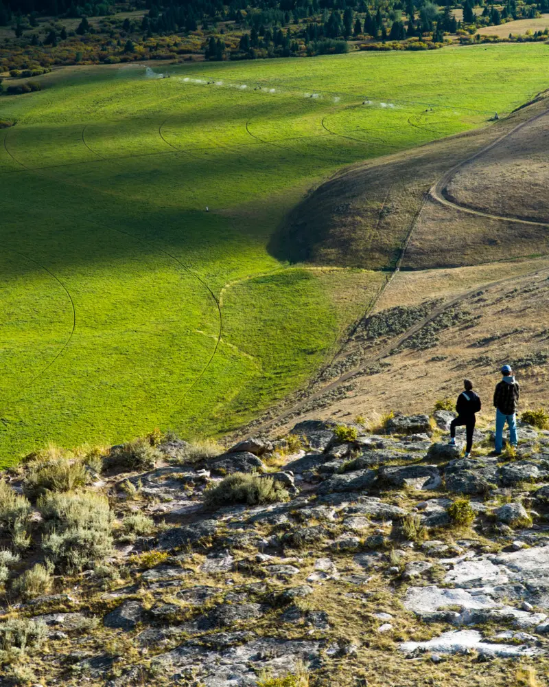 Two people on a hillside overlooking a valley