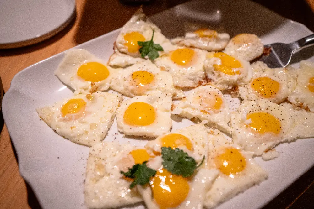 A plate of eggs with herbs on top