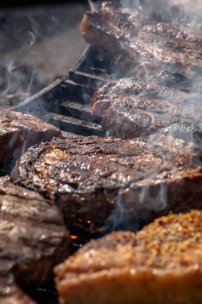 A close up of a grill with raw meat on it