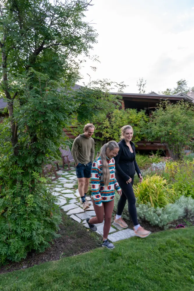 Three people walking in a garden