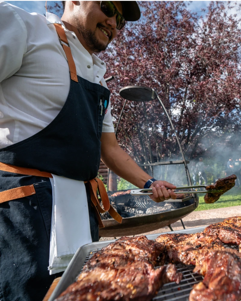 A man cooking meat on a grill