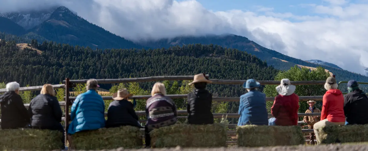 People sitting on a bench, looking at the mountains