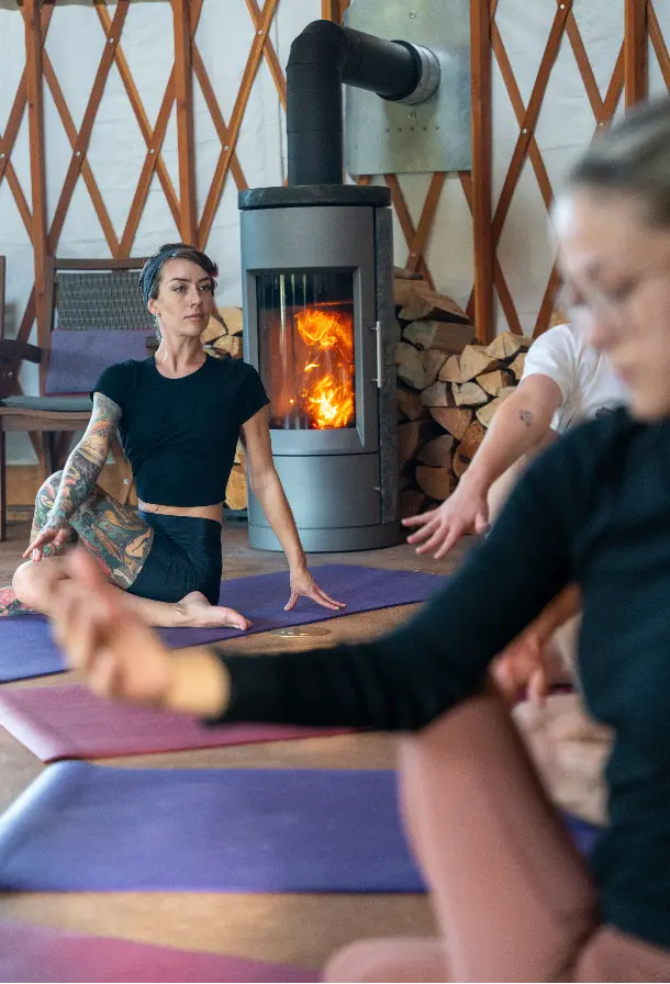 A woman doing yoga in front of a fireplace