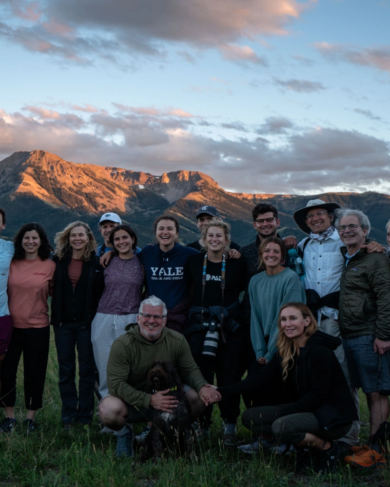 A group of people and a dog on a mountain top