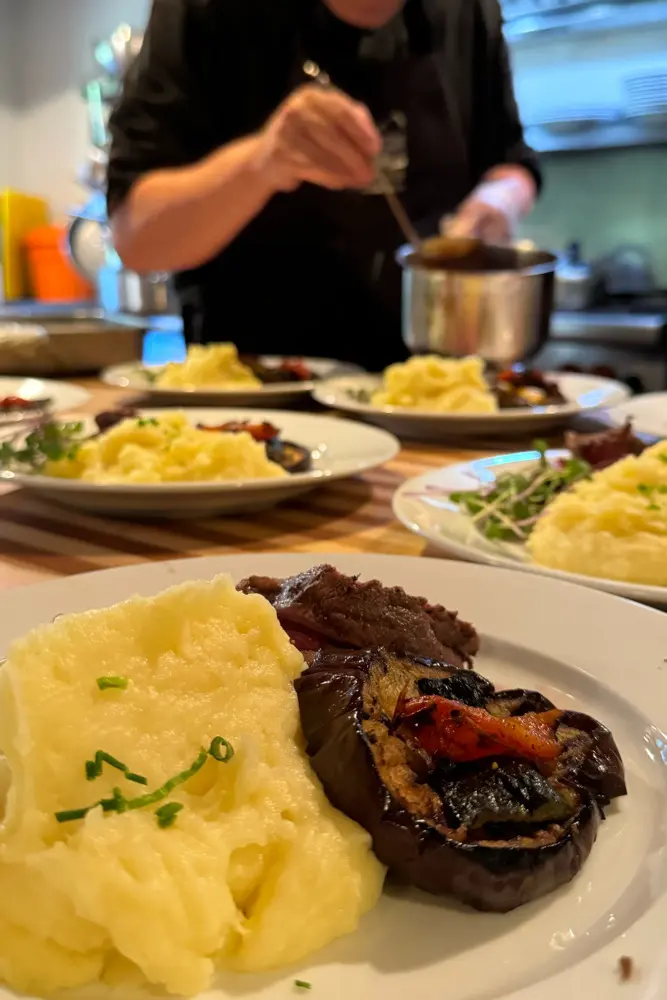 A chef preparing a meal with various foods on a dining table