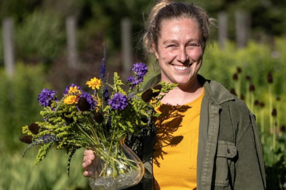 A woman holding a vase of flowers